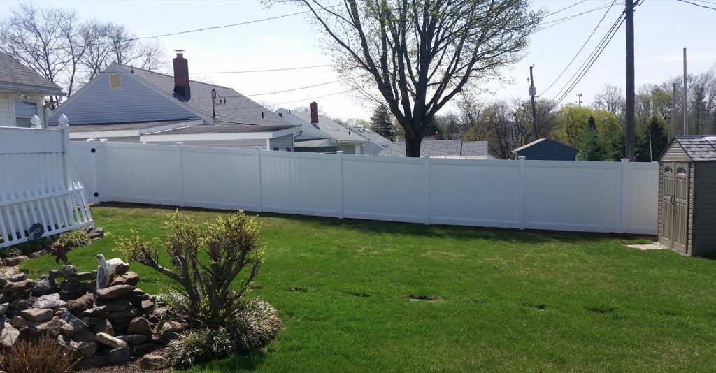 white fencing of a lush green yard